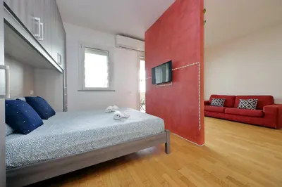 a bedroom with a bed with a red wall at Claudias flat by DomusDimore in Rome