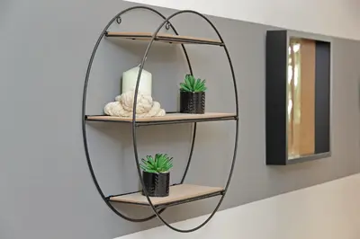 a round mirror hanging on a wall with two plants at Micheles Flat by DomusDimore in Rome
