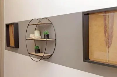 a round mirror on a wall with two plants at Micheles Flat by DomusDimore in Rome