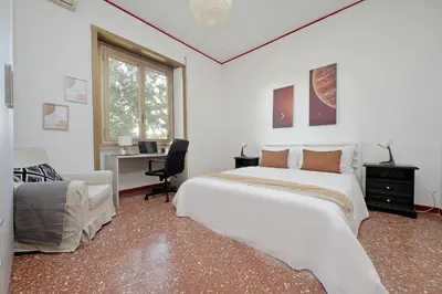 a white bedroom with a large bed and a desk at Micheles Flat by DomusDimore in Rome