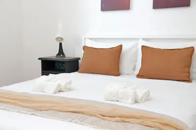 a white bed with four pillows and a table at Micheles Flat by DomusDimore in Rome
