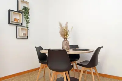 a dining room table with four chairs and a vase on it at Micheles Flat by DomusDimore in Rome