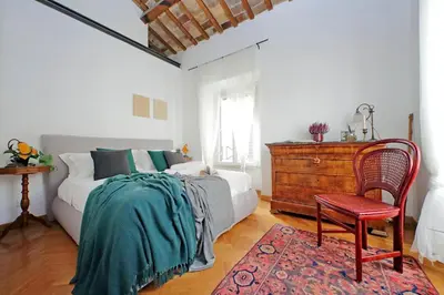 a bedroom with a bed and a chair and a dresser at Piazza Venezia Apartment in Rome