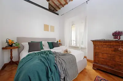 a bedroom with a white bed and a dresser at Piazza Venezia Apartment in Rome