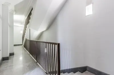 a hallway with white walls and a wooden staircase at The Terrace Luxury in Rome