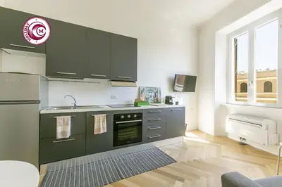 a kitchen with black cabinets and a sink and an oven at C M Civitas Leonina Luxury in Rome