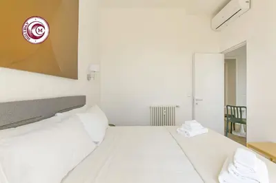 a bedroom with a white bed with avertisementatronatronatronstrationstrationstrationstration at C M Civitas Leonina Luxury in Rome