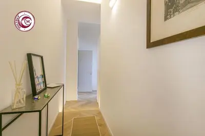 a hallway with a table and a clock on a wall at C M Civitas Leonina Luxury in Rome