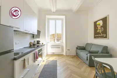 a kitchen and a living room with a couch at C M Il Passetto di Borgo Pio in Rome