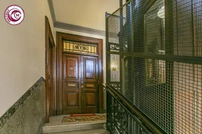 a staircase leading to a wooden door with a fence at C M Il Passetto di Borgo Pio in Rome