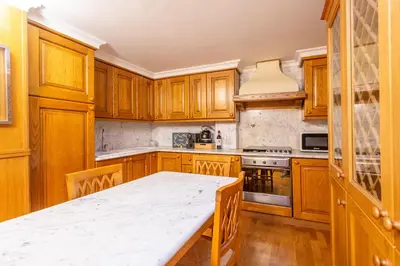 a kitchen with wooden cabinets and a white counter top at Easybnb - Bear Home in Rome