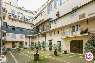 a row of apartment buildings with potted trees in a courtyard at Palazzo Scapucci Apartment a Navona in Rome