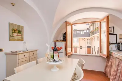 a kitchen with a white table and a window at Palazzo Scapucci Apartment a Navona in Rome