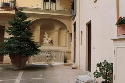 a building with a bench and a tree in a courtyard at Palazzo Scapucci Apartment a Navona in Rome