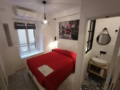 a bedroom with a red bed and a sink at SamDom's Home City Station termini Rome in Rome