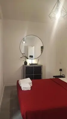 a bedroom with a red bed and a mirror at SamDom's Home City Station termini Rome in Rome