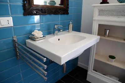 a bathroom with a white sink and blue tiles at Nido Degli Angeli in Rome