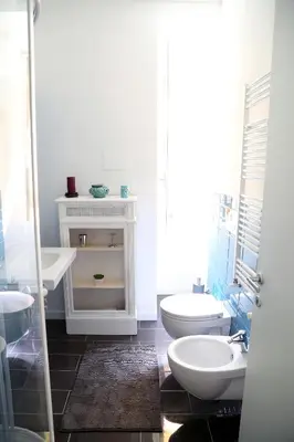 a white bathroom with two sinks and a toilet at Nido Degli Angeli in Rome