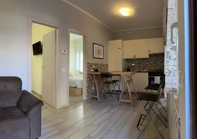 a kitchen and living room with a couch and a table at Casina dei Gemelli in Rome