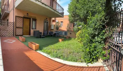 a courtyard of a house with a yard with a patio at Casina dei Gemelli in Rome