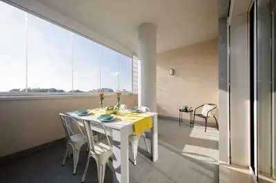 a white table and chairs in a room with large windows at Martas flat by DomusDimore in Rome