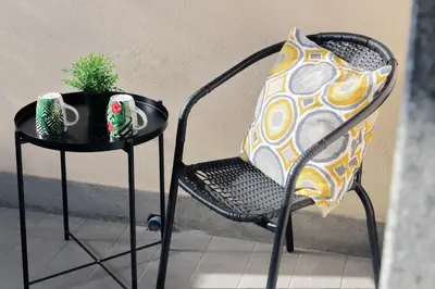 a table and a chair with a pillow and a plant at Martas flat by DomusDimore in Rome