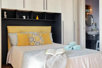 a bedroom with a bed with a book and a sink at Martas flat by DomusDimore in Rome