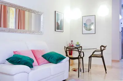 a living room with a white couch and a table at Mario Suite Spagna in Rome