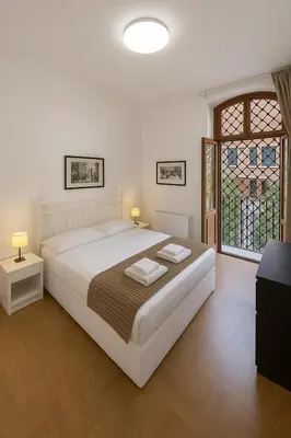 a white bedroom with a large bed and a window at Femi apartments in Rome