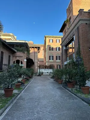 an empty alley with potted trees and brick buildings at Femi apartments in Rome
