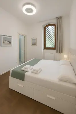 a white bedroom with a large bed with towels on it at Femi apartments in Rome