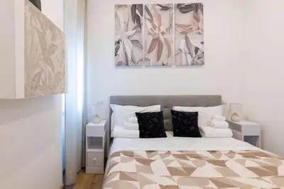 a white bedroom with a bed and a mirror at Arya Roma San Pietro in Rome
