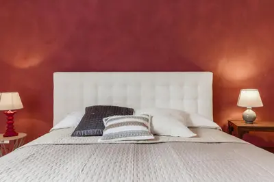 a bedroom with a white bed with two lamps at Santonofrio Apartments in Rome