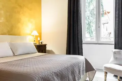 a bedroom with a bed and a window and a chair at Santonofrio Apartments in Rome