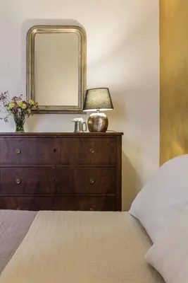 a bedroom with a dresser with a mirror and a bed at Santonofrio Apartments in Rome