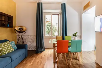 a living room with a blue couch and colorful chairs at Santonofrio Apartments in Rome
