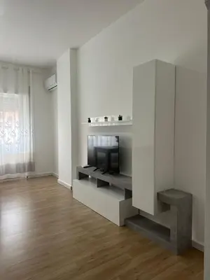 a white living room with a flat screen tv at La Casa Romana in Rome