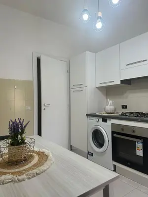 a kitchen with a table and a washing machine at La Casa Romana in Rome