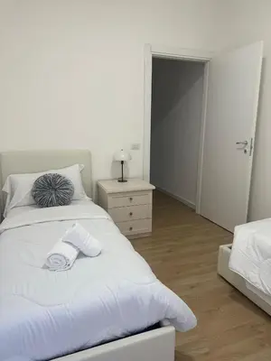 a white bedroom with a bed with towels on it at La Casa Romana in Rome