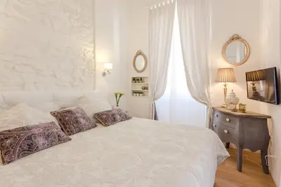 a bedroom with a white bed with pillows on it at La Casa Di Teo in Rome