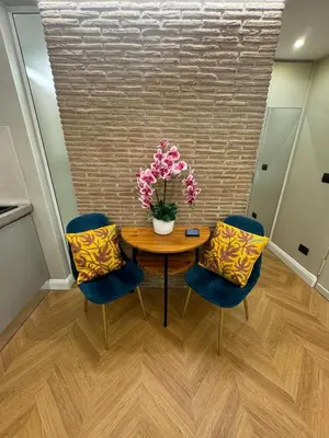 a table with two chairs and a vase with flowers on it at Vatican Loft - Liberty Collection in Rome