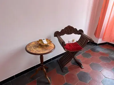 a table and a chair sitting next to a wall at Domus Alexandra in Rome