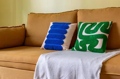 a brown couch with two pillows on it at iFlat Colorful New Apartment in Esquilino in Rome