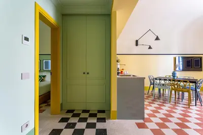 a kitchen and dining room with green cabinets and a table at iFlat Colorful New Apartment in Esquilino in Rome
