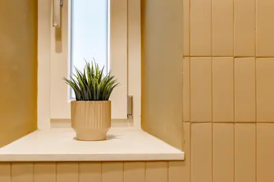 a plant sitting on a window sill in a bathroom at iFlat Colorful New Apartment in Esquilino in Rome