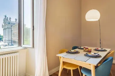 a dining room with a table and chairs and a window at Appartamento panoramico vicino al Colosseo in Rome