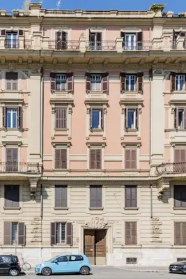 a blue car parked in front of a large building at Appartamento panoramico vicino al Colosseo in Rome