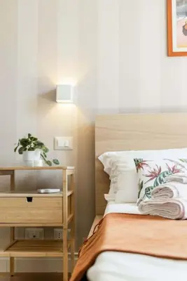 a bedroom with a bed and a night stand with a plant at Appartamento panoramico vicino al Colosseo in Rome