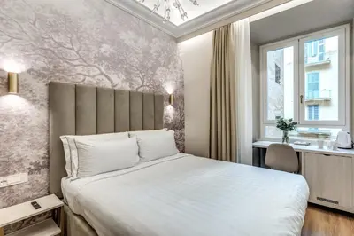 a bedroom with a large white bed and a window at Lumi Hotel in Rome