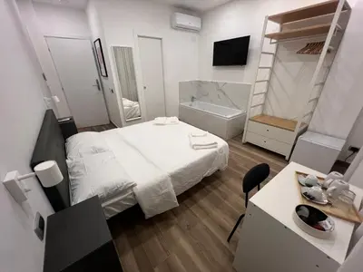 a small bedroom with a bed and a bath tub at Suite 98 in Rome